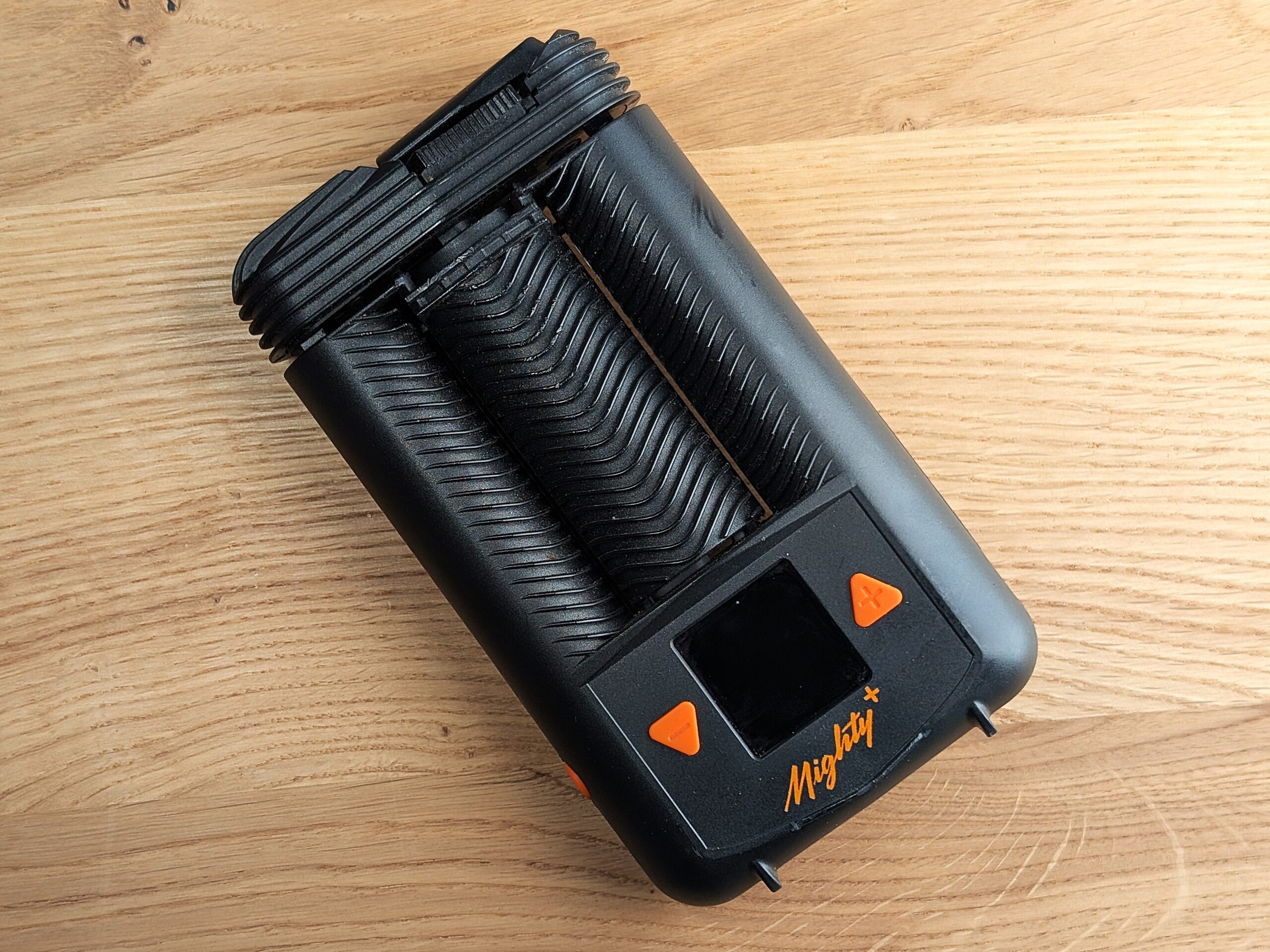 The Mighty Plus vaporizer lying on a wooden table.