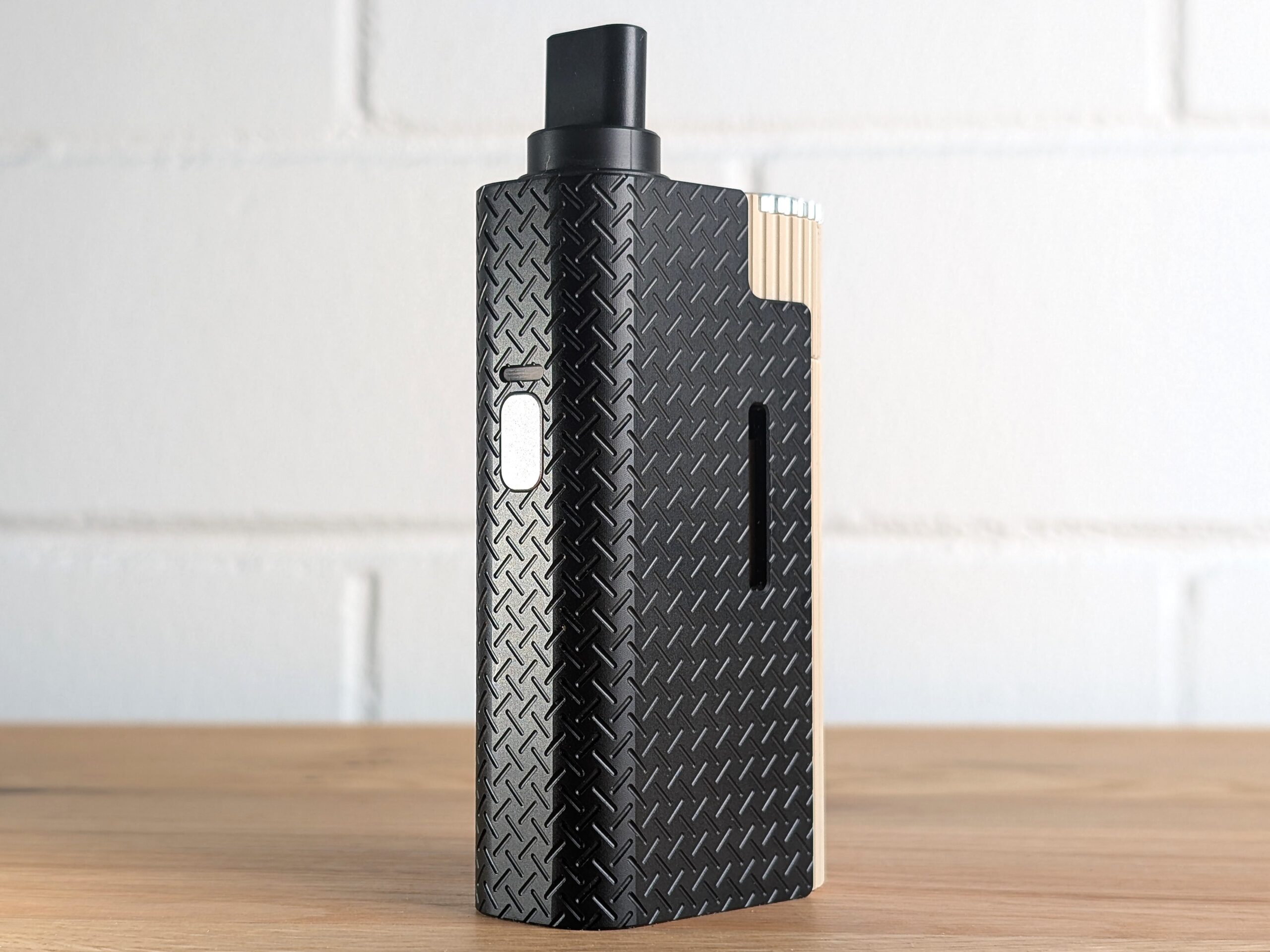 Der Frolic Thermal Extractor steht auf einem Holztisch. Im Hintergrund ist eine unscharfe weiße Backsteinwand zu erkennen.