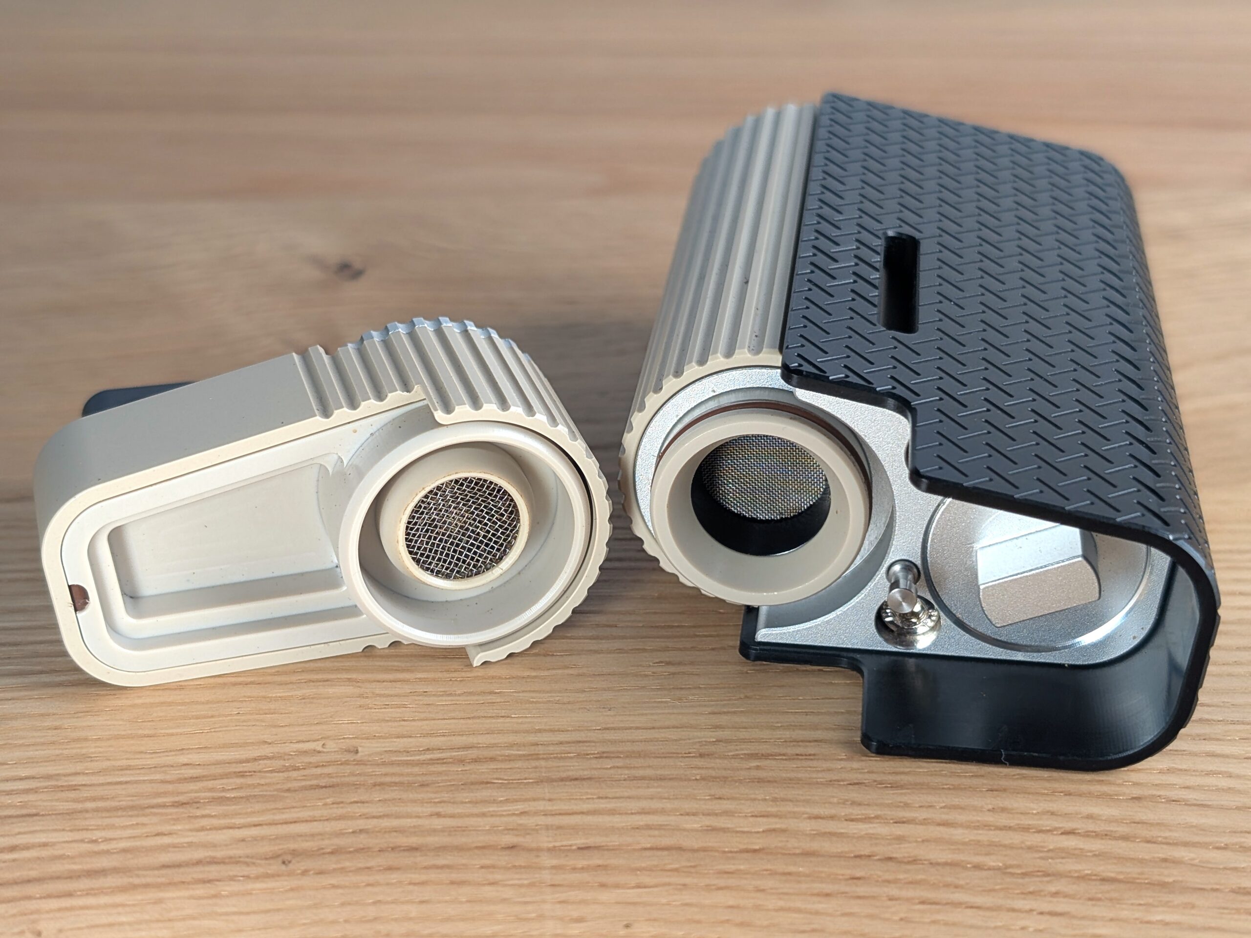 Der Frolic liegt seitlich auf einem Holztisch. Links daneben liegt Kühleinheit. Die Innenseite zeigt zum Betrachter.