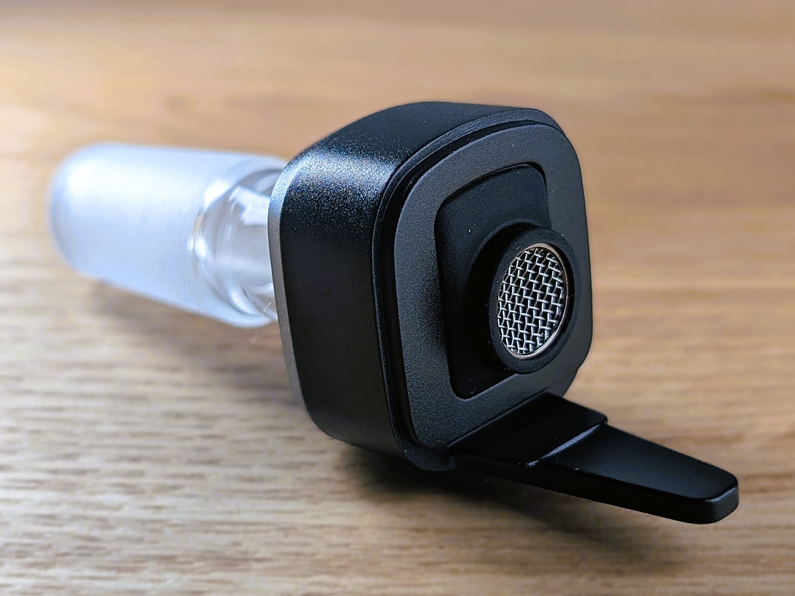 Der Wasserfilteradapter des Cuboo-Stick-Vaporizers liegt auf einem Holztisch.