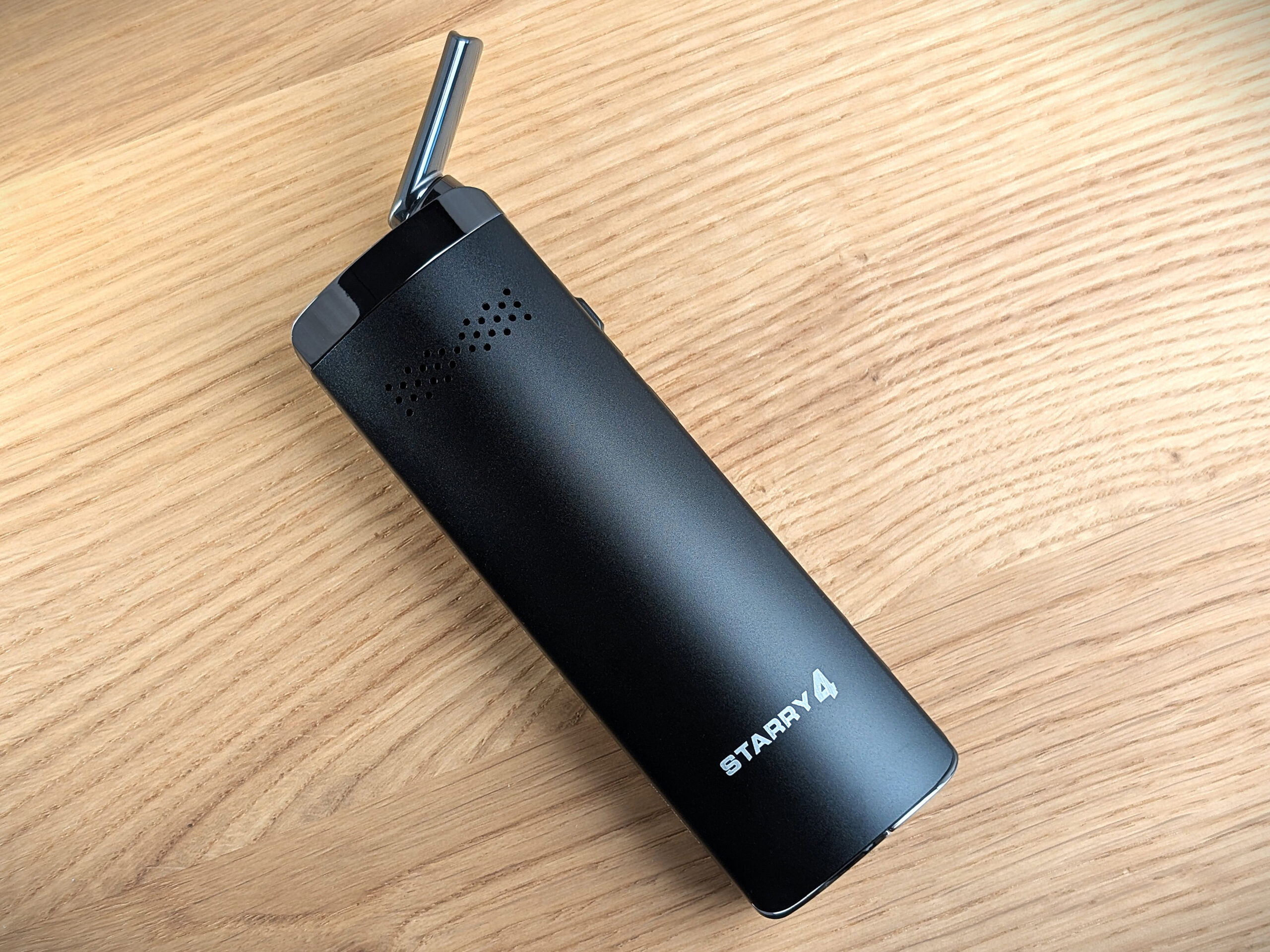 The Starry 4 Vaporizer lying on a wooden table.