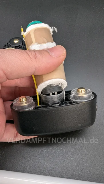 Eine Hand hält den geöffneten Angus Enhanced fest. Die offene Fiberglas-Isolierung ist zu erkennen.