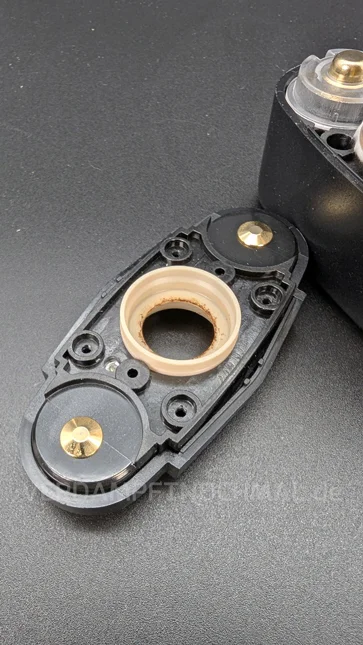 The top cover of the Angus Enhanced is lying on a table. The inside is facing up. No fibers from the insulation are visible.