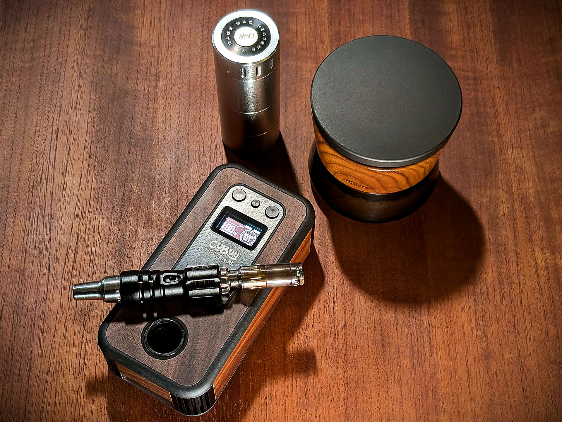 Mad Heaters Reload, Stona Grinder, and Cuboo Heater XL are on a wooden table. A Mad Heaters Tempest 2 is on top of the Cuboo Heater XL.