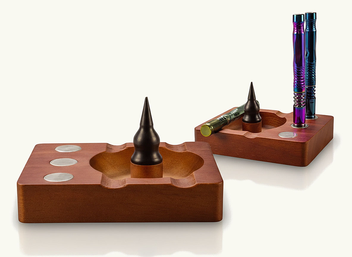 Zwei magnetische Zubehörstationen aus dunklem Holz mit integrierten Dornen zum Entleeren der Kräuterkammer und Halterungen für Vaporizer.