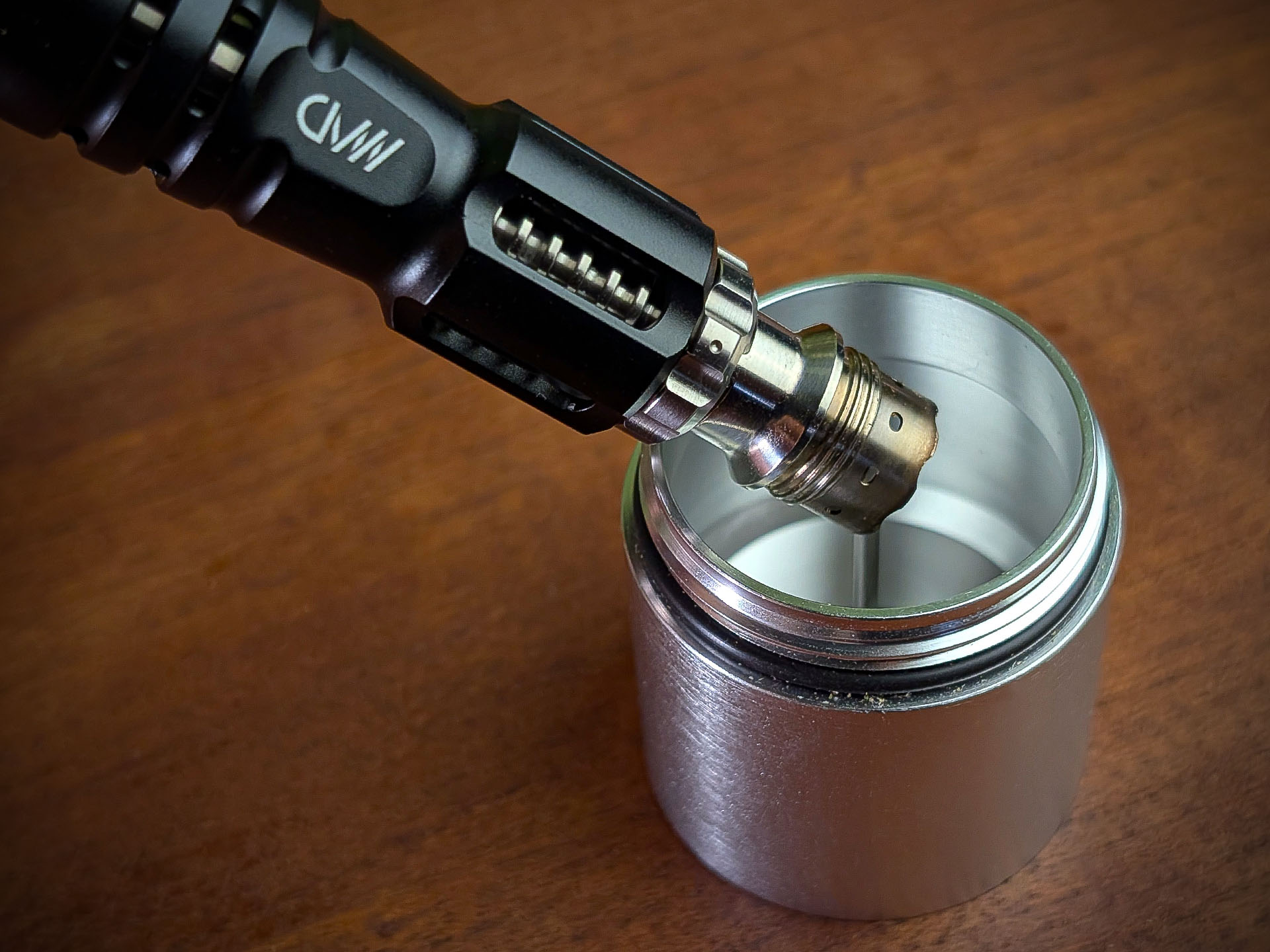 The decapper of the Mad Heaters Reload 3 sits on a wooden table with the Tempest 2 bowl attached to the debowler tip.