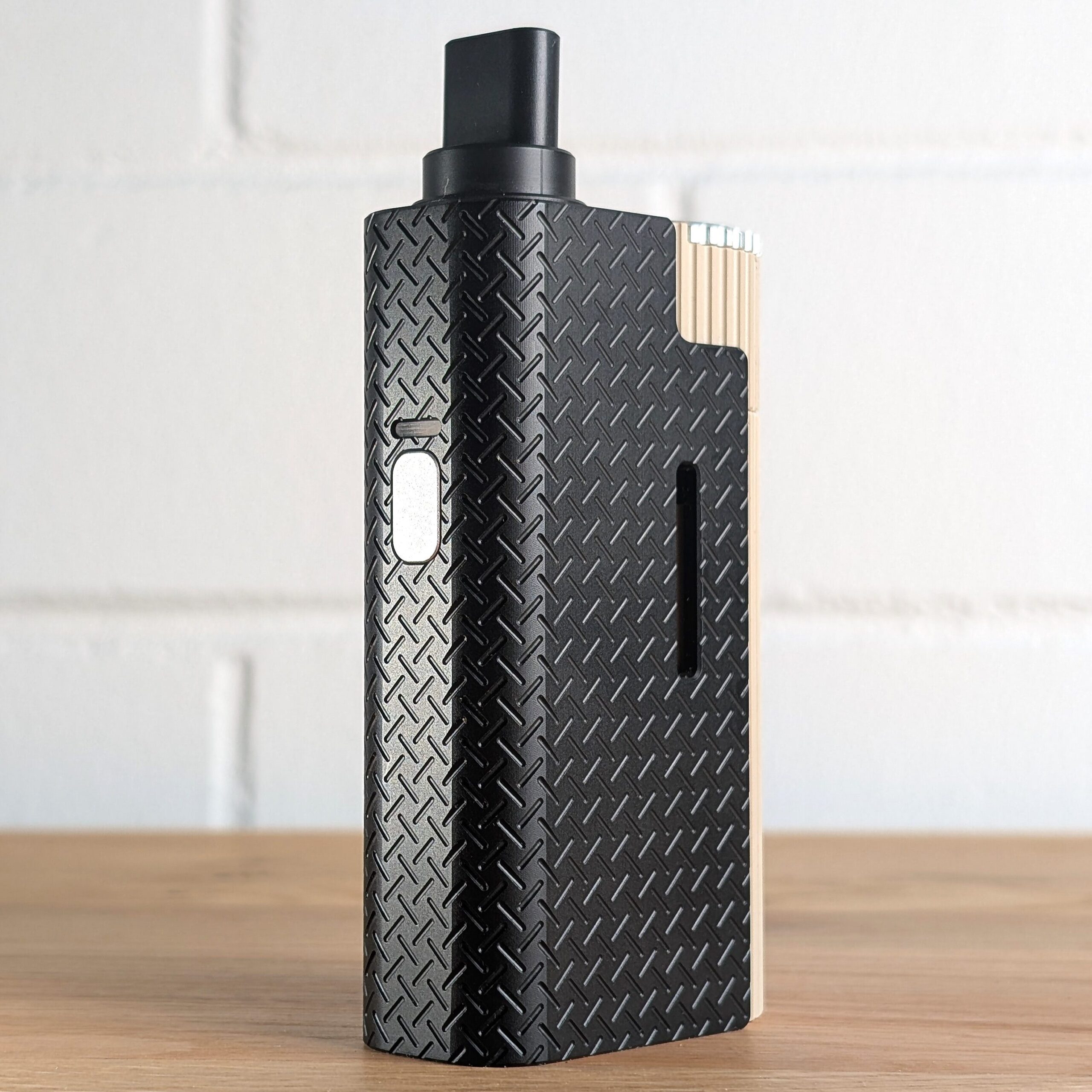 Der Frolic Thermal Extractor steht auf einem Holztisch. Im Hintergrund ist eine unscharfe weiße Backsteinwand zu erkennen.