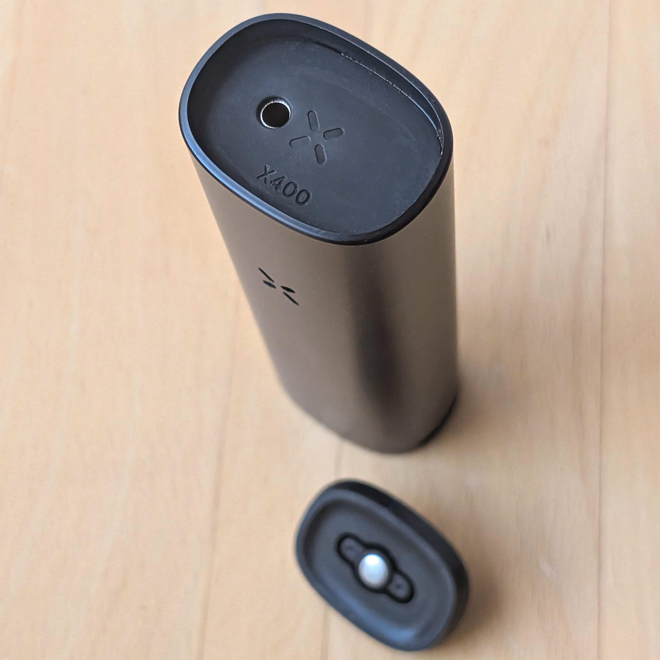 Draufsicht auf den PAX FOUR mit abgenommenem Mundstück, die den Blick auf den Einschaltknopf und die „X400“-Prägung freigibt.
